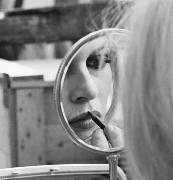 Brigitte Bardot zieht sich die Lippen nach.