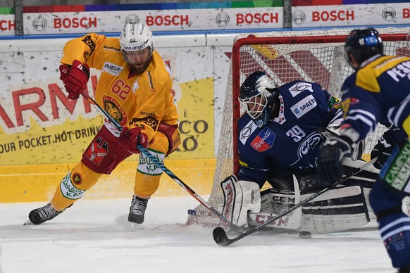 Tigers Alexei Dostoinov, links, und Ambris Goalie Sandro Zurkirchen, rechts, im Spiel um den Puck im Eishockey Meisterschaftsspiel der National League A zwischen dem HC Ambri-Piotta und den SCL Tigers ...