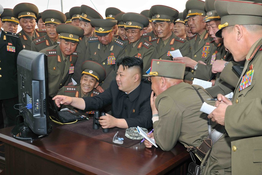 epa04183185 An undated picture released by the North Korean Central News Agency (KCNA) on 27 April 2014 shows North Korean leader Kim Jong-un (C) looking at a computer along with soldiers of a long-ra ...
