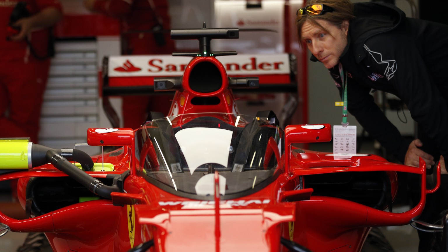 A man inspects the windshield installed on the Ferrari car of Sebastian Vettel of Germany ahead of the first practice at the British Formula One Grand Prix free practice at the Silverstone racetrack,  ...