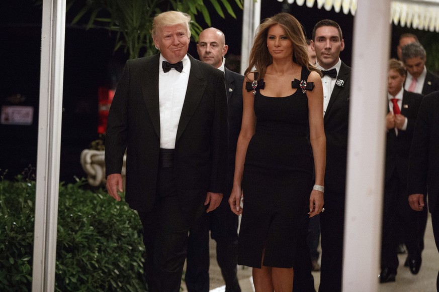 President-elect Donald Trump, left, and his wife Melania Trump arrive for a New Year&#039;s Eve party at Mar-a-Lago, Saturday, Dec. 31, 2016, in Palm Beach, Fla. (AP Photo/Evan Vucci)