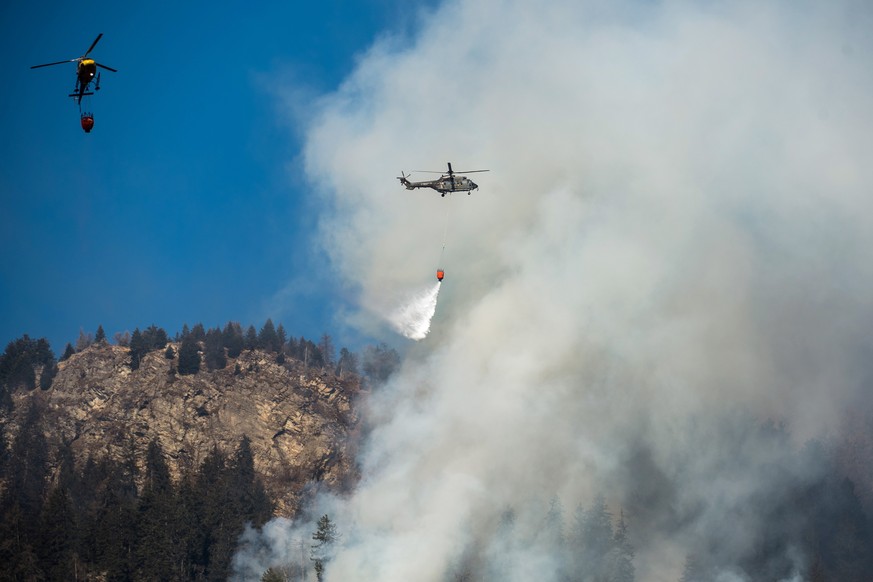 Swiss army Superpuma Helicopters discharges water over the forest fires near Mesocco in Southern Switzerland, Wednesday, December 28, 2016. (KEYSTONE/Ti-Press/Gabriele Putzu)