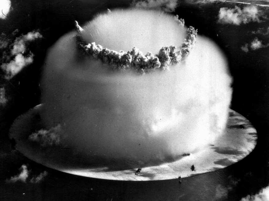 A huge mushroom cloud rises above Bikini atoll in the Marshall Islands July 25, 1946 following an atomic test blast, part of the U.S. military&#039;s &quot;Operation Crossroads.&quot; The dark spots i ...
