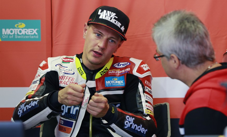 Moto2 rider Dominique Aegerter of Switzerland talks with his team staff during a free practice session for the MotoGP Japanese Motorcycle Grand Prix at the Twin Ring Motegi circuit in Motegi, north of ...