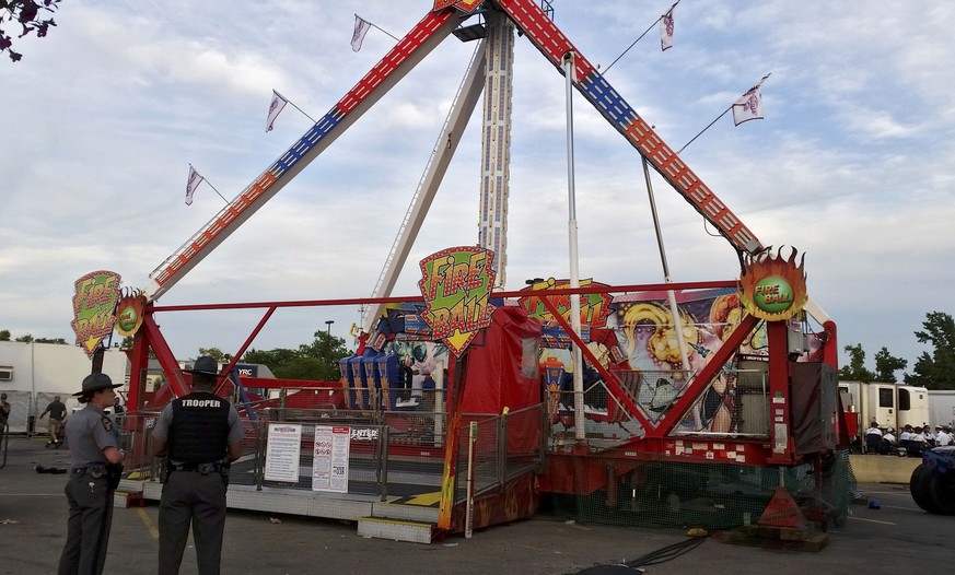 Authorities stand near the Fire Ball amusement ride after the ride malfunctioned injuring several at the Ohio State Fair, Wednesday, July 26, 2017, in Columbus, Ohio. Some of the victims were thrown f ...