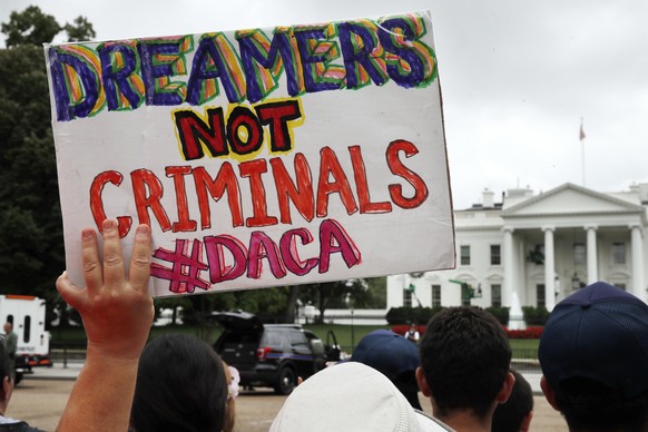 FILE- In this Aug. 15, 2017, file photo, a woman holds up a signs in support of the Obama administration program known as Deferred Action for Childhood Arrivals, or DACA, during an immigration reform  ...