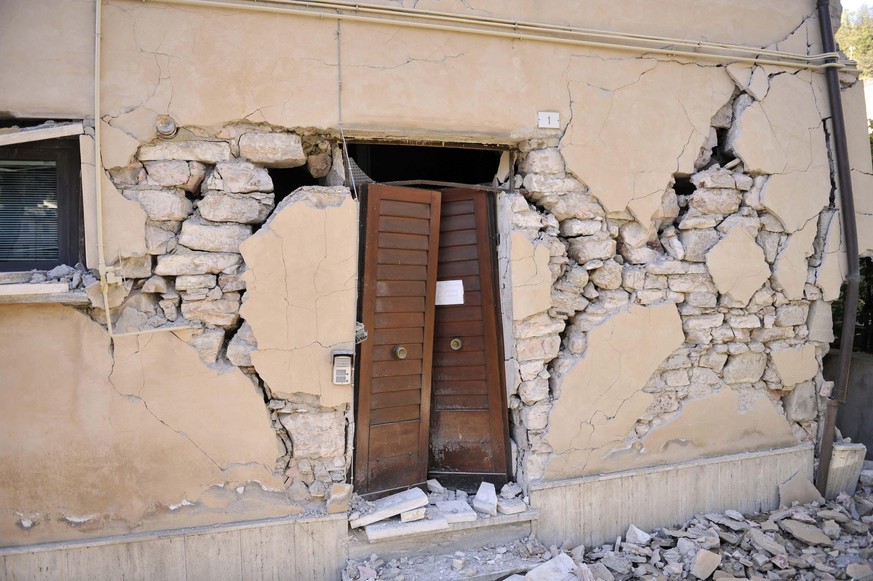 epa05605864 The damaged facade of a building in Visso, near Macerata, a day after two big earthquakes shook central Italy, Visso, Italy, 27 October 2016. At least 200 aftershocks followed the first of ...