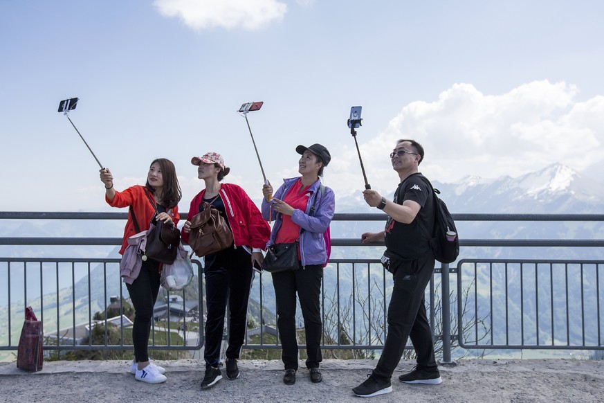epa05993269 Asian tourists enjoy the sunny weather and take selfies on the Stanserhorn mountain, in the canton of Nidwalden, Switzerland, 27 May 2017. EPA/ALEXANDRA WEY