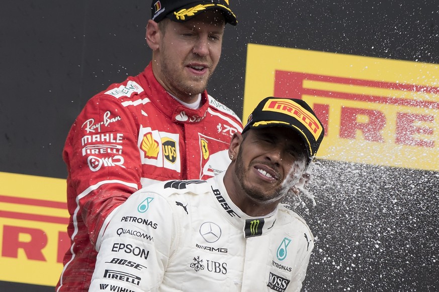 epa06166520 Winner British Formula One driver Lewis Hamilton of Mercedes AMG GP (R) and second placed German Formula One driver Sebastian Vettel of Scuderia Ferrari (L) celebrate on the podium after t ...