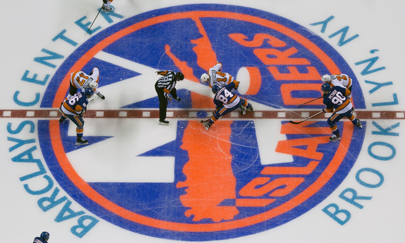 New York Islanders center Mikhail Grabovski (84) and Philadelphia Flyers center Sean Couturier (14) face off during the first period of an NHL preseason hockey game at the Barclays Center in New York, ...