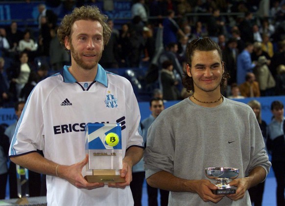 Marc Rosset ( L) and Roger Federer of Switzerland hold their trophies after the final of the Open 13 tennis tournament in Marseille February 13. Rosset won the match 2-6,6-3,7-6 - RTXJIOO