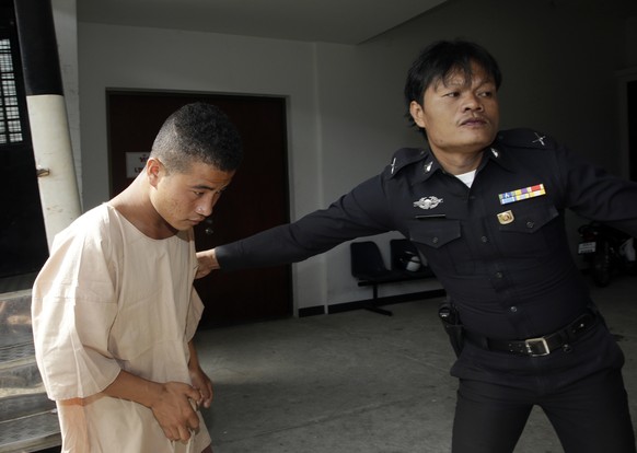 Myanmar migrant worker Win Zaw Htun, left, arrives at a provincial court in Surat Thani province, Thailand Wednesday, July 8, 2015. Ten months after two British tourists were killed on a resort island ...