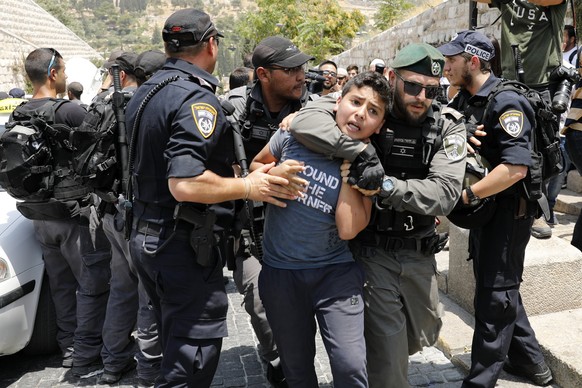 epa06092676 Israeli border police arrest a young Palestinian as hundreds of Palestinian Muslim worshipers pray in front of the Lions&#039; Gate near the entrance to the al-Aqsa compound in Jerusalem&# ...
