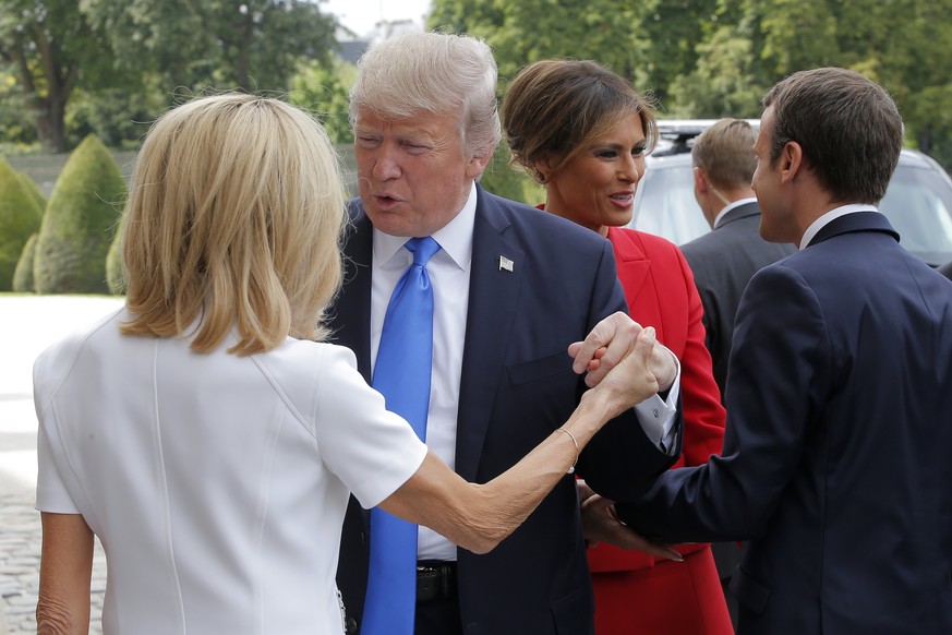 epa06085016 French President Emmanuel Macron (R) welcomes First Lady Melania Trump (2-R) while his wife Brigitte (L) welcomes US President Donald J. Trump at Les Invalides museum in Paris, France, 13  ...