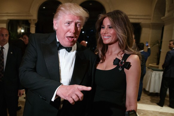 Melania Trump, right, looks on as her husband President-elect Donald Trump talks to reporters during a New Year&#039;s Eve party at Mar-a-Lago, Saturday, Dec. 31, 2016, in Palm Beach, Fla. (AP Photo/E ...