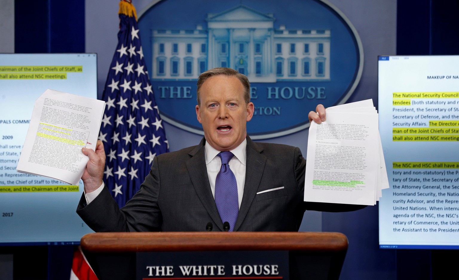 White House spokesman Sean Spicer holds up documents comparing the makeup of the National Security Council (NSC) in the Trump and Obama administrations during his press briefing at the White House in  ...