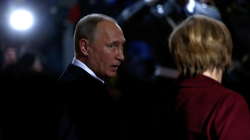 Russian President Vladimir Putin talks to German Chancellor Angela Merkel as he arrives for talks on a stalled peace plan for eastern Ukraine at the chancellery in Berlin, Germany, October 19, 2016. R ...