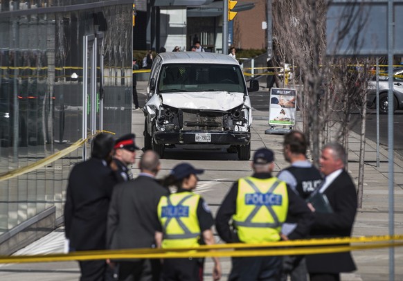 FILE - In this April 23, 2018, file photo, police stand near a damaged van after a van mounted a sidewalk crashing into pedestrians in Toronto. Alek Minassian accused of driving a van into pedestrians ...
