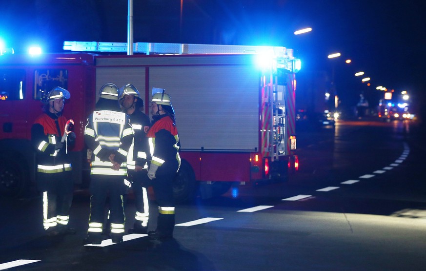 epa05431095 Firefighters stand at a road block in Wuerzburg, Germany, 18 July 2016. Reports state that a man allegedly wielding an axe injured multiple passengers on a regional train in Wuerzburg. EPA ...