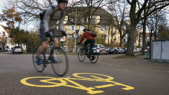 Fahrradfahrer fahren an einem Fahrradpiktogramm an der Velostrasse Scheuchzerstrasse in Zuerich vorbei, aufgenommen am Montag, 28. November 2016. Die Stadt Zuerich testet ab Montag, 28. November 2016, ...