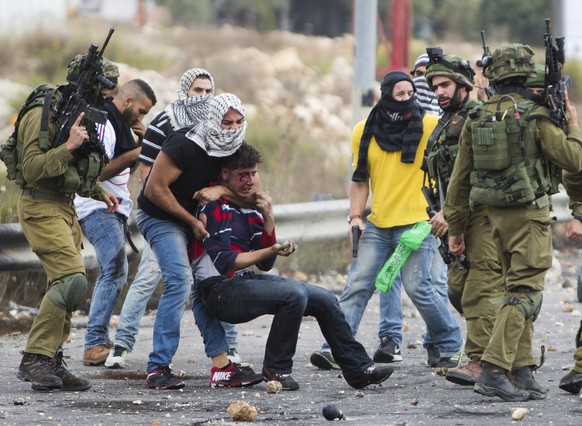 Mit der Kufiya («Palästinensertuch») verhüllt: Beamte nehmen einen mutmasslichen Steinewerfer fest.