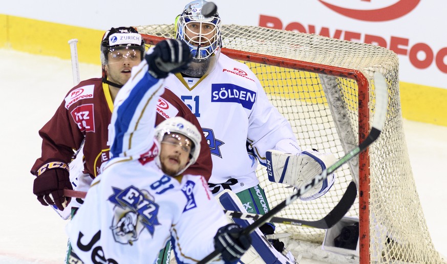 Le joueur zougois, Marc Marchon, centre, lutte pour le puck avec le joueur genevois, Juraj Simek, gauche, devant le gardien genevois, Robert Mayer, droite, lors du match de hockey sur glace de demi-fi ...