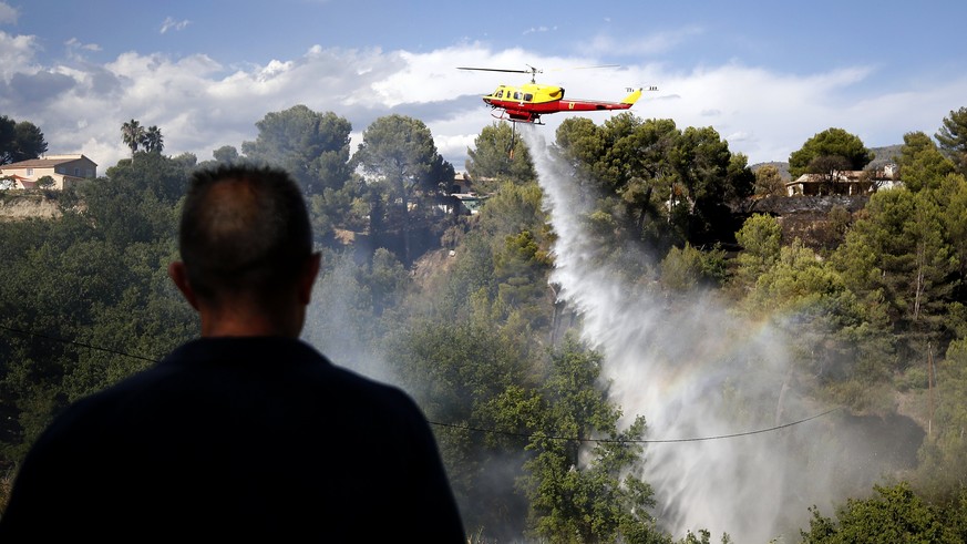 epa06108974 A firefighting helicopter drops water over a forest fire in Carros near Nice, southern France, 25 July 2017. EPA/SEBASTIEN NOGIER