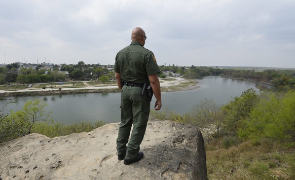 epa05191888 United States Border Patrol agent Jose Perales looks across the Rio Grande River at Mexico from the United States near McAllen, Texas, USA, 02 March 2016. The nearly two thousand mile Unit ...
