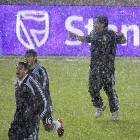 Under pouring rain, Argentina&#039;s coach Diego Maradona, center, celebrates at the end of a 2010 World Cup qualifying soccer match against Peru in Buenos Aires, Saturday, Oct. 10, 2009. Argentina wo ...