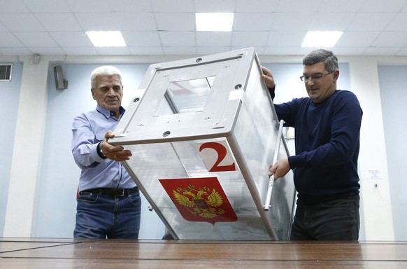 epa05546564 Members of a local election commission empty ballot box as they start counting votes after the polling station closed in Moscow, Russia, 18 September 2016. Russians are called to the polls ...