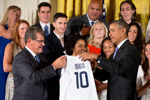 UConn Huskies Women&#039;s head basketball coach Geno Auriemma, left, presents President Barack Obama with a UConn Huskies jersey in the East Room of the White House in Washington, Tuesday, Sept. 15,  ...