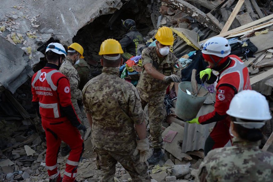 epa05510650 A handout picture released by the Italian Army (Esercito Italiano, EI) Press Office on 26 August 2016, shows rescue teams working amid the rubble of collapsed buildings during a search and ...
