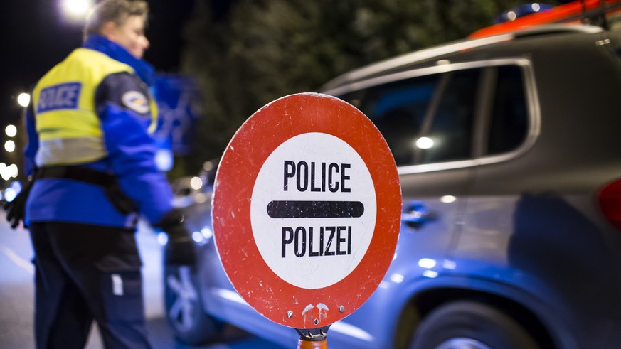 Des policiers controlent des automobilistes lors d&#039;un controle de circulation comprenant la police et la gendarmerie genevoise et vaudoise ainsi que les gardes frontieres ce mardi soir 23 decembr ...