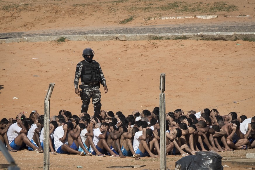 A Military Police officer stands next to inmates during a head count in the Alcacuz prison in Nisia Floresta, near Natal, Brazil, Tuesday, Jan. 24, 2017. Military police entered the prison in northeas ...