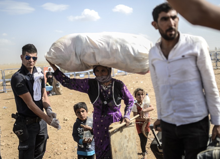 Syrische Kurden fliehen aus der belagerten Grenzstadt Ain al-Arab in die Türkei.&nbsp;