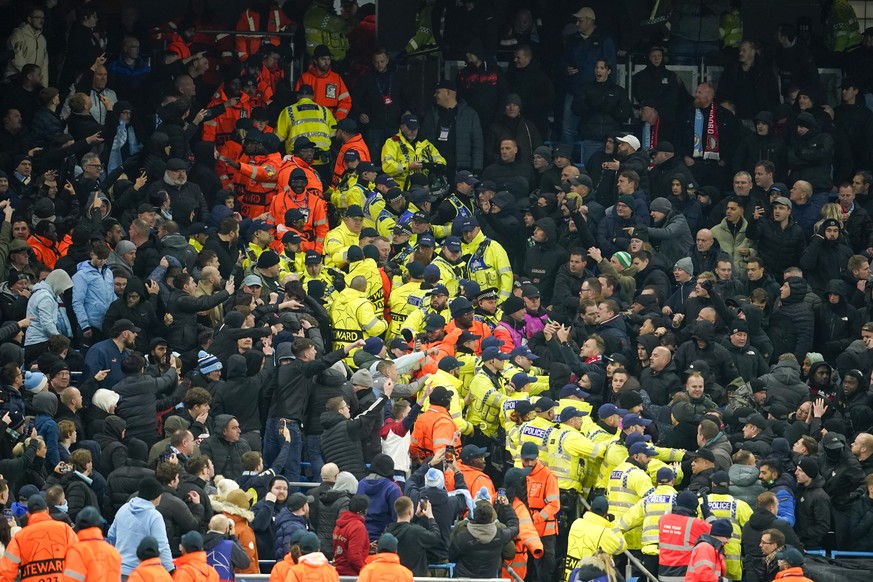 Nachrichten Linkding Police and stewards form a line to separate City and Feyenoord, right, fans during the Champions League opening phase soccer match between Manchester City and Feyenoord at the Etihad Stadium in Manche ...