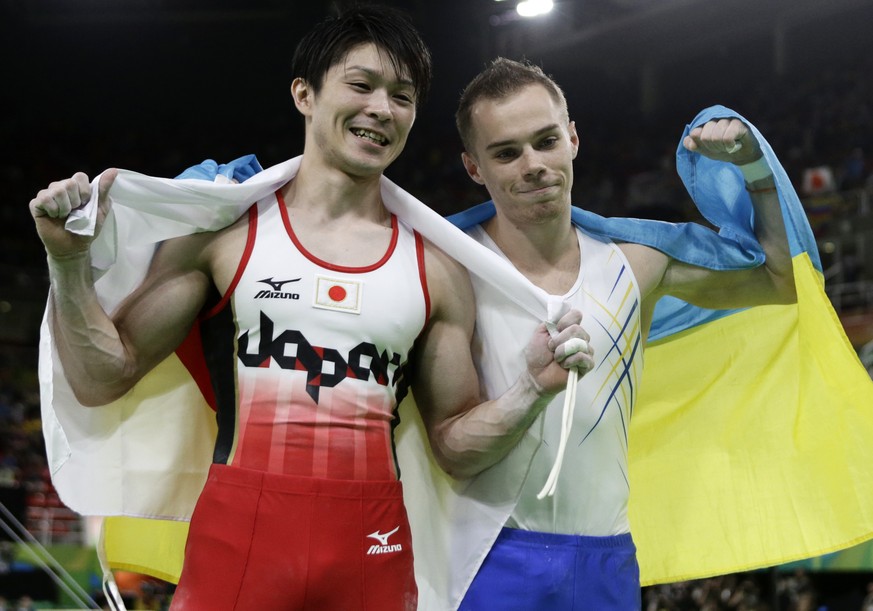 Gold medallist Japan&#039;s Kohei Uchimura, left, and silver medallist Ukraine&#039;s Oleg Verniaiev pose for photographers at the end of the artistic gymnastics men&#039;s individual all-around final ...