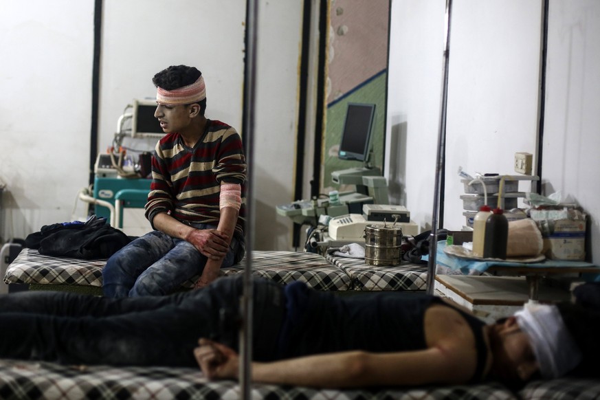 epa05888128 Injured men receive treatment in a field hospital after airstrikes by forces allegedly loyal to the Syrian government, rebel-held Douma, Syria, 04 April 2017. More than 30 people got injur ...