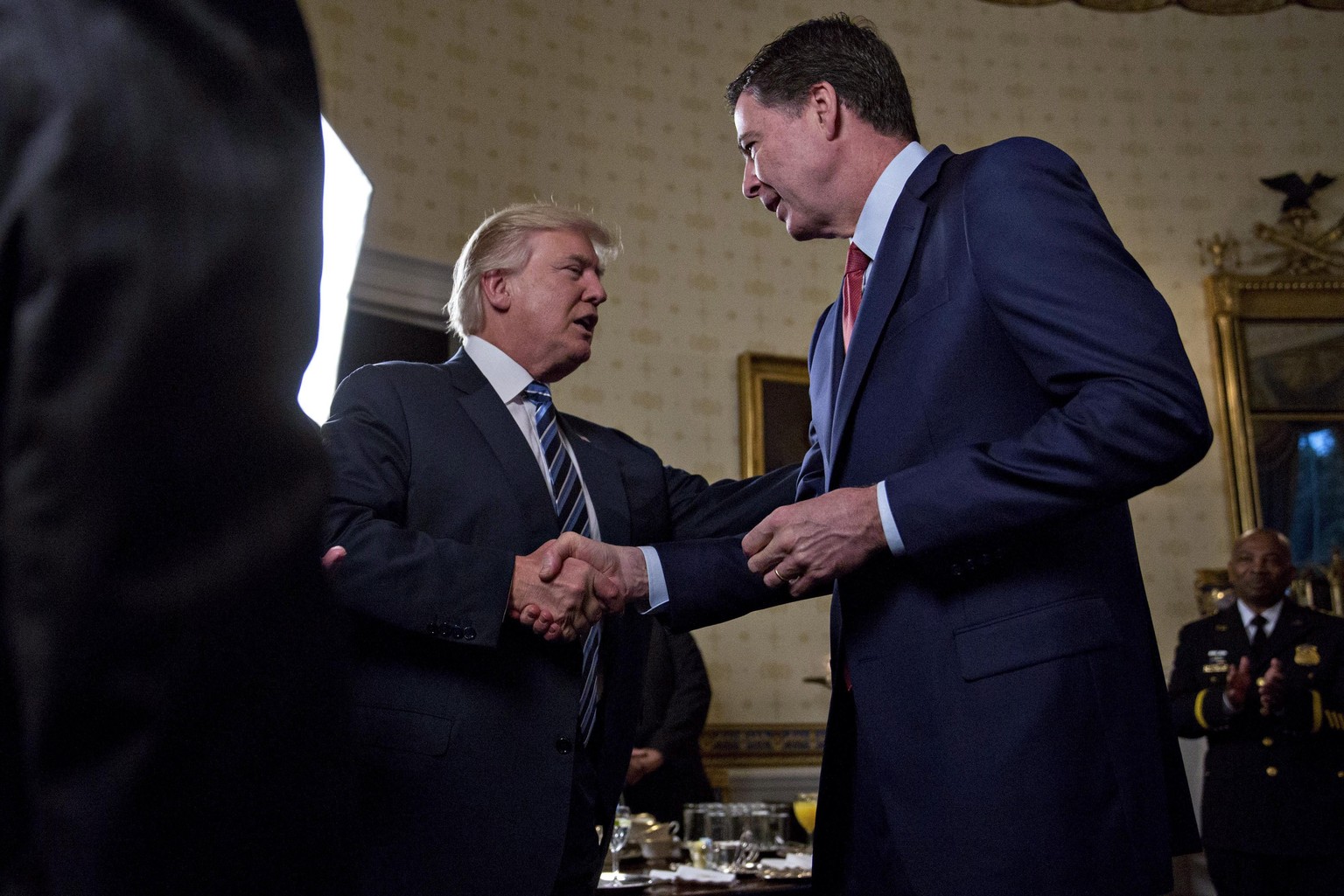 epa05742575 US President Donald J. Trump, center, shakes hands with James Comey, director of the Federal Bureau of Investigation (FBI), during an Inaugural Law Enforcement Officers and First Responder ...