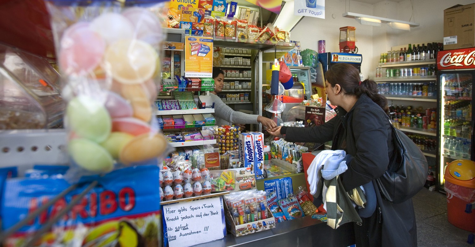 Eine Kundin kauft bei einem privaten Kiosk am Kannenfeldplatz in Basel ein, am 5. Oktober 2006. Im Kanton Basel-Stadt gelten fuer Familienbetriebe im Verkaufssektor erweiterte Ladenoeffnungszeiten. Wa ...