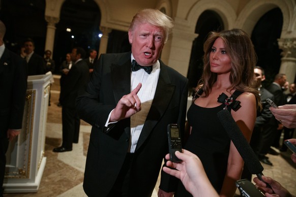 Melania Trump, right, looks on as her husband President-elect Donald Trump talks to reporters during a New Year&#039;s Eve party at Mar-a-Lago, Saturday, Dec. 31, 2016, in Palm Beach, Fla. (AP Photo/E ...