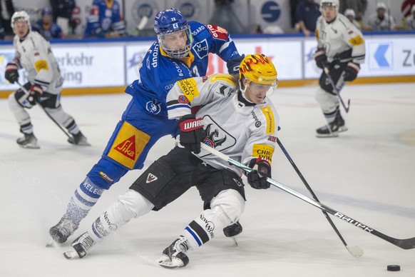 Nachrichten Linkding Mike Kuenzle, links, von Zug im Spiel gegen PostFinance Top Scorer Marcus Soerensen, rechts, von Fribourg beim Eishockey Qualifikationsspiel der National League zwischen dem EV Zug und dem HC Fribourg ...