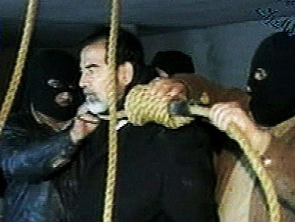 FILE - This image made from video released by Iraqi state television shows Saddam Hussein&#039;s guards wearing ski masks and placing a noose around the deposed leader&#039;s neck moments before his e ...