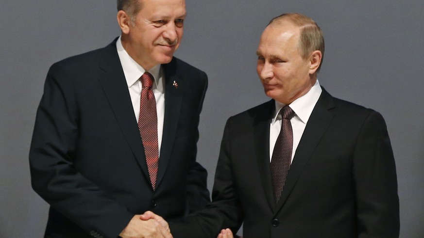 Turkey&#039;s President Recep Tayyip Erdogan, left and Russian President Vladimir Putin, right, shake hands following the group photo at the World Energy Congress, in Istanbul, Monday, Oct. 10, 2016.  ...