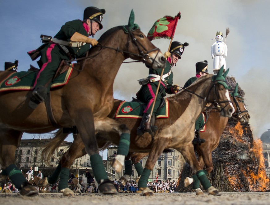 Reiter einer Zunft galoppieren um den brennenden Boeoegg, anlaesslich des traditionellen Sechselaeutens am Montag, 13. April 2015, in Zuerich. (KEYSTONE/Ennio Leanza)....Members of a guild ride around ...