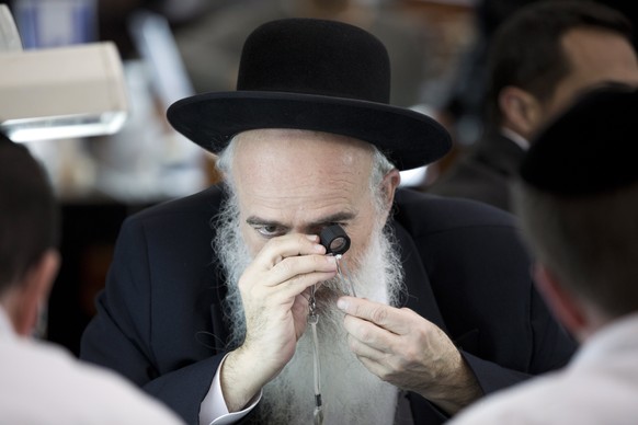 epa05794586 Diamond traders examine diamonds at the Israeli Diamond Exchange trading floor during the 6th International Diamond Week in the Israeli city of Ramat Gan, near Tel Aviv, Israel, 15 Februar ...