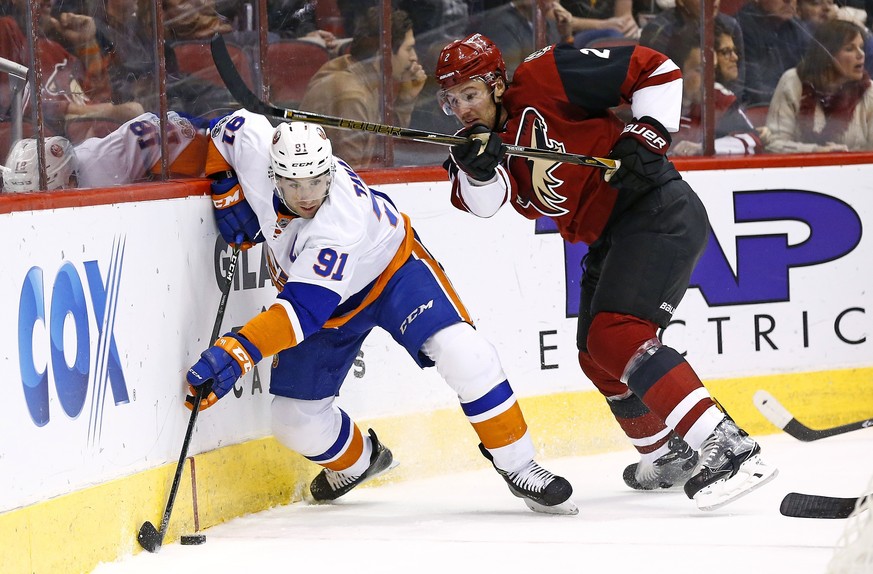 New York Islanders center John Tavares (91) skates with the puck against Arizona Coyotes defenseman Luke Schenn (2) during the first period of an NHL hockey game Saturday, Jan. 7, 2017, in Glendale, A ...