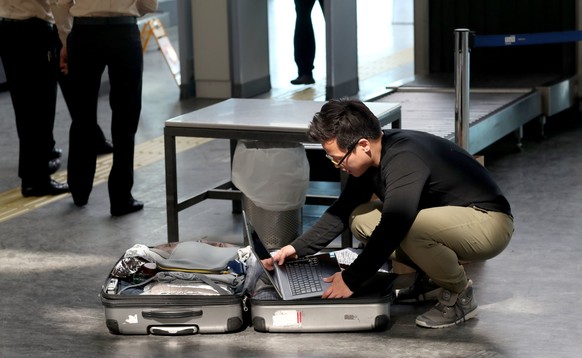 epa05862908 Passengers open their luggage and show their electronic equipment at security point at the Ataturk Airport, in Istanbul, Turkey, 2017. The United State and Britain have banned some electro ...