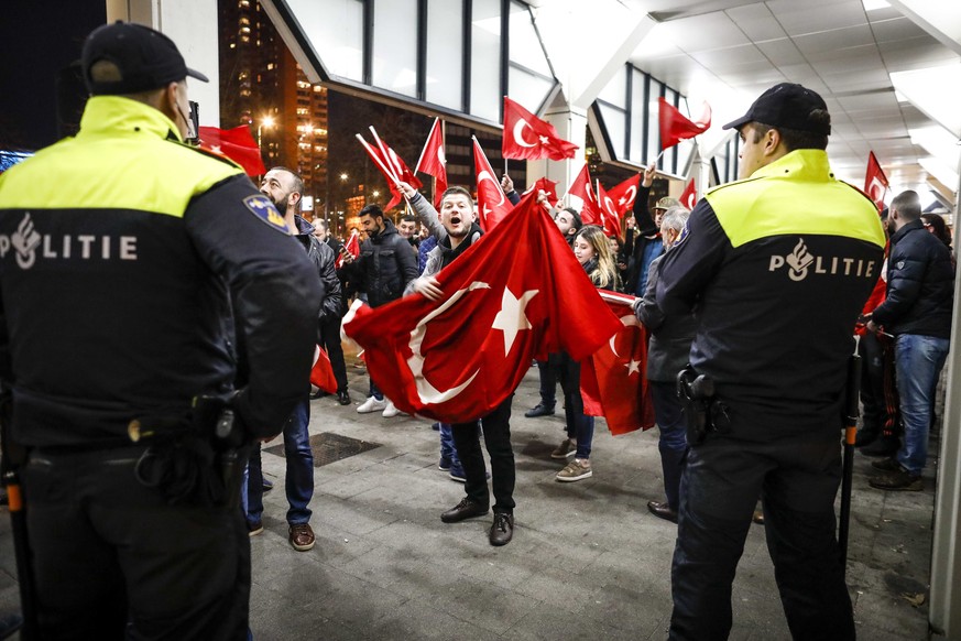 epa05843193 Demonstrators wave Turkish flags as they protest outside the Turkish consulate in Rotterdam, the Netherlands, 11 March 2017. The protesters were demanding to see the Turkish Family Ministe ...