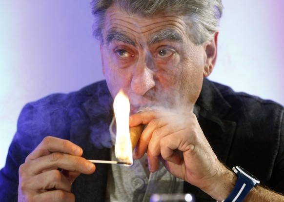 Nick Hayek Jr, Swatch Group Chief Executive, lights a cigar during the Swiss watch maker annual news conference in Plan-Les-Ouates near Geneva in this March 20, 2014 file photo. Swiss companies are cu ...